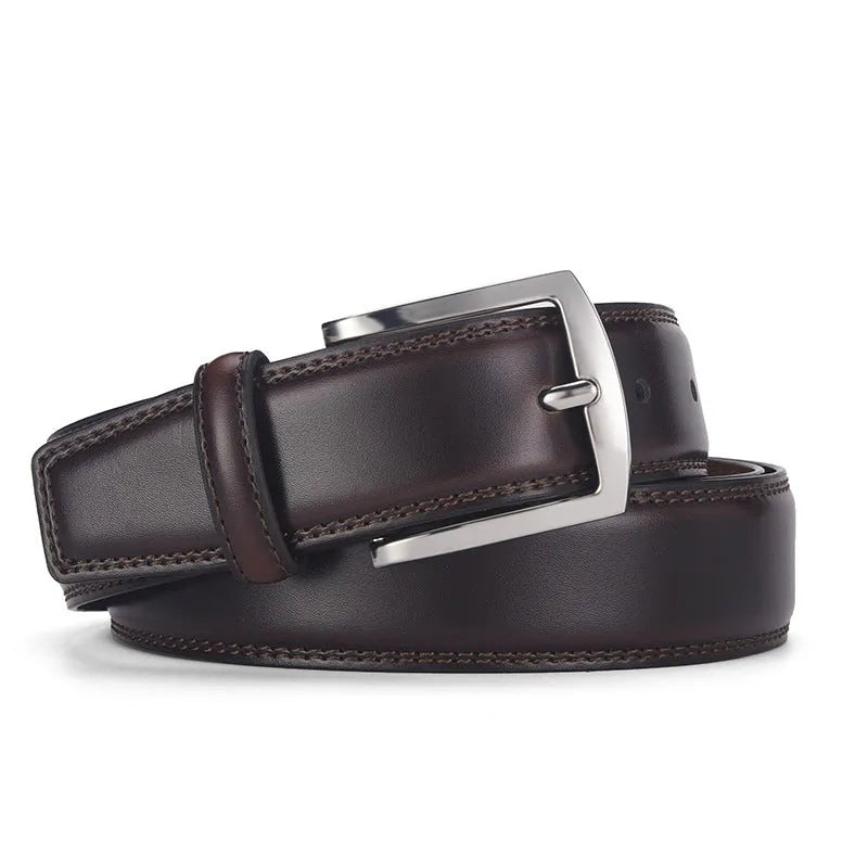 Men's classic black genuine leather belt with a silver-toned alloy pin buckle on a flat surface.