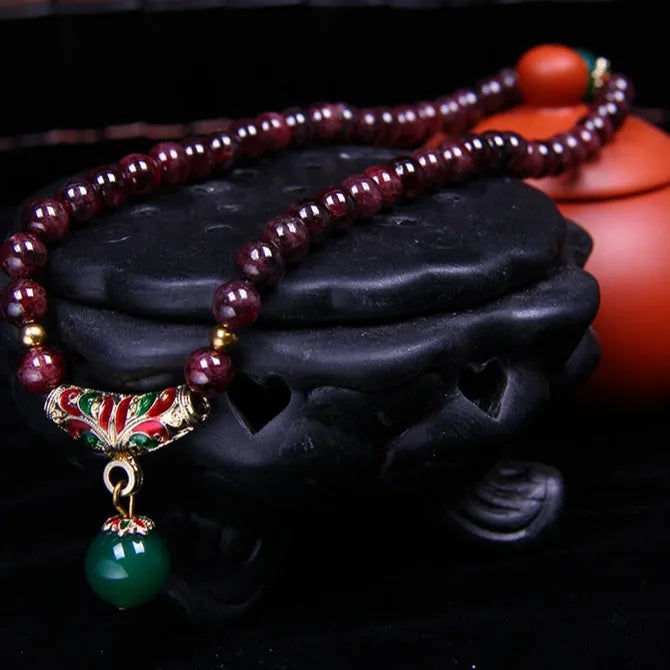 Women's natural garnet bracelet with 7mm beads, double ring closure and Golden Toad charm