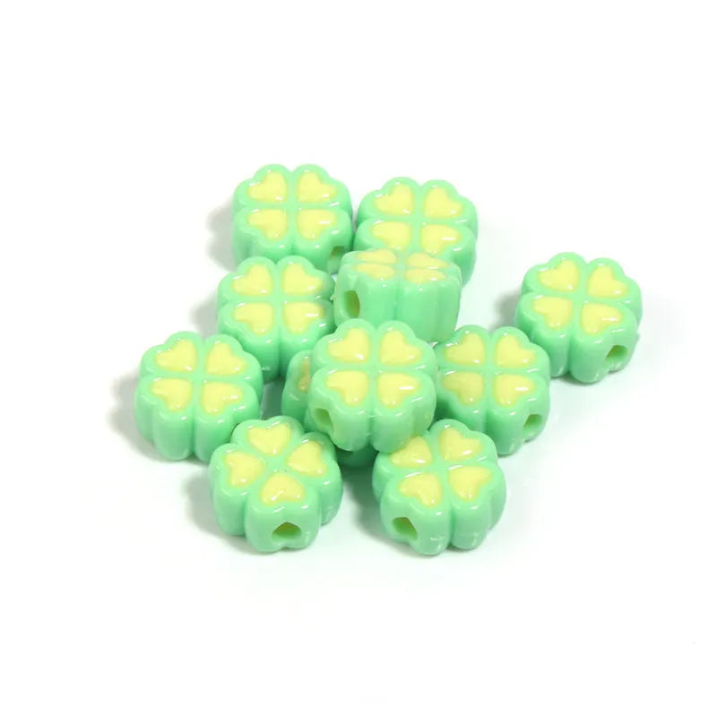 A selection of 15mm frosted acrylic beads in various colours, each showing a four-leaf clover love pattern.