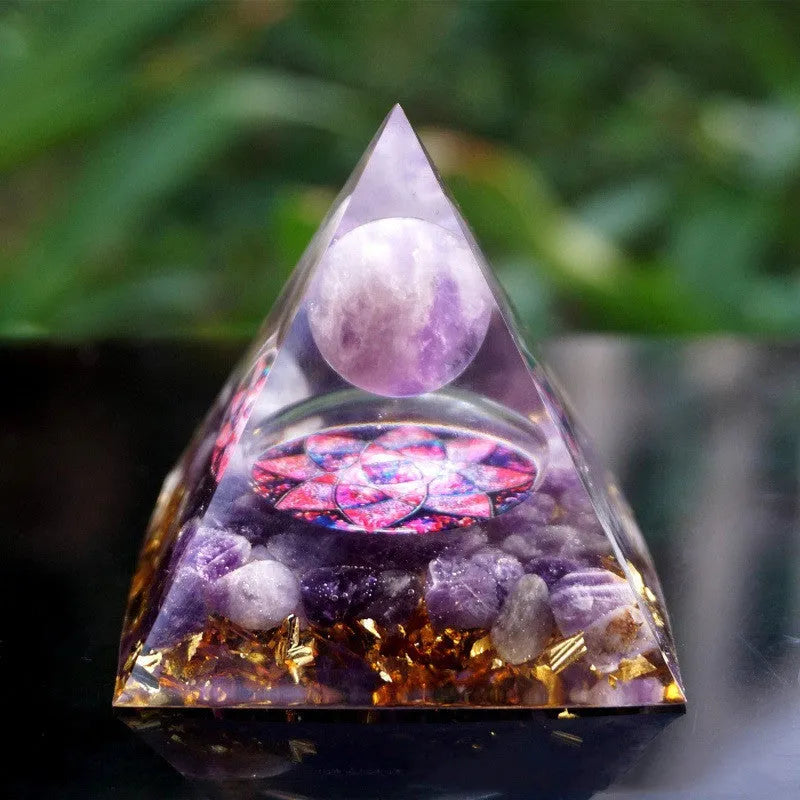 A 6cm high clear resin pyramid ornament filled with colourful crystal gravel on a wooden surface.