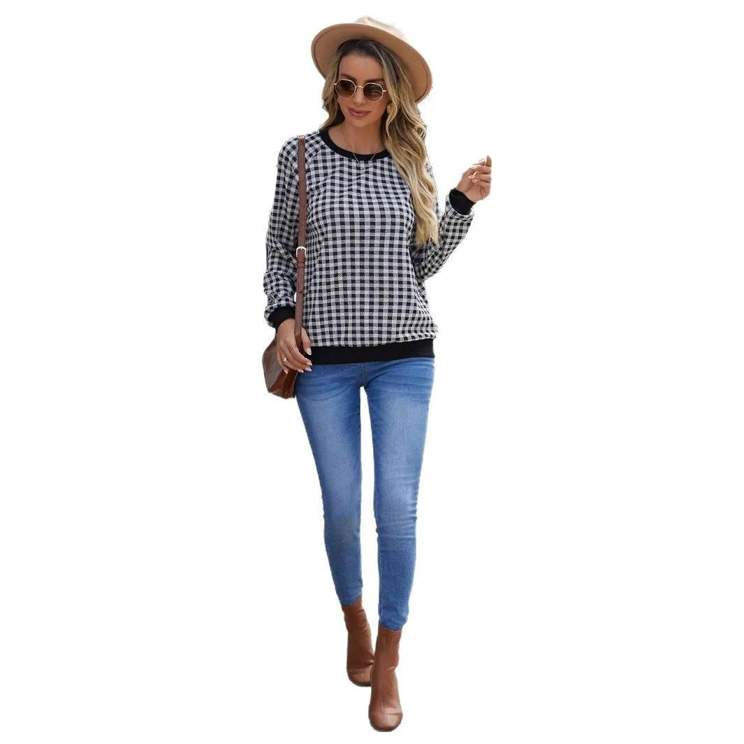 Black plaid pattern long sleeve polyester pullover sweater on a hanger.