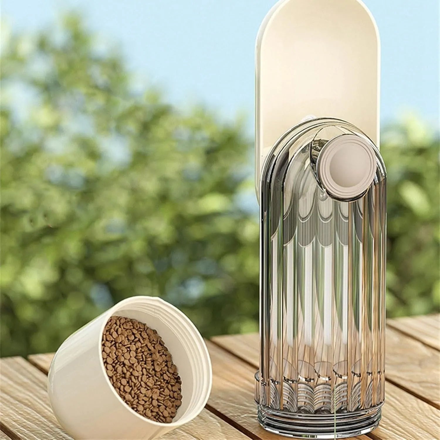 Beige and green foldable dog water bottle with food dispenser base for outdoor walking and travel.
