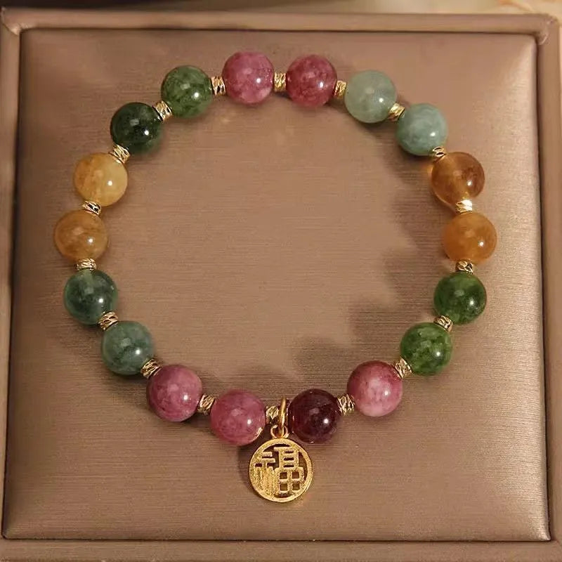 Tourmaline bracelet with floral or fu character design on a white background.