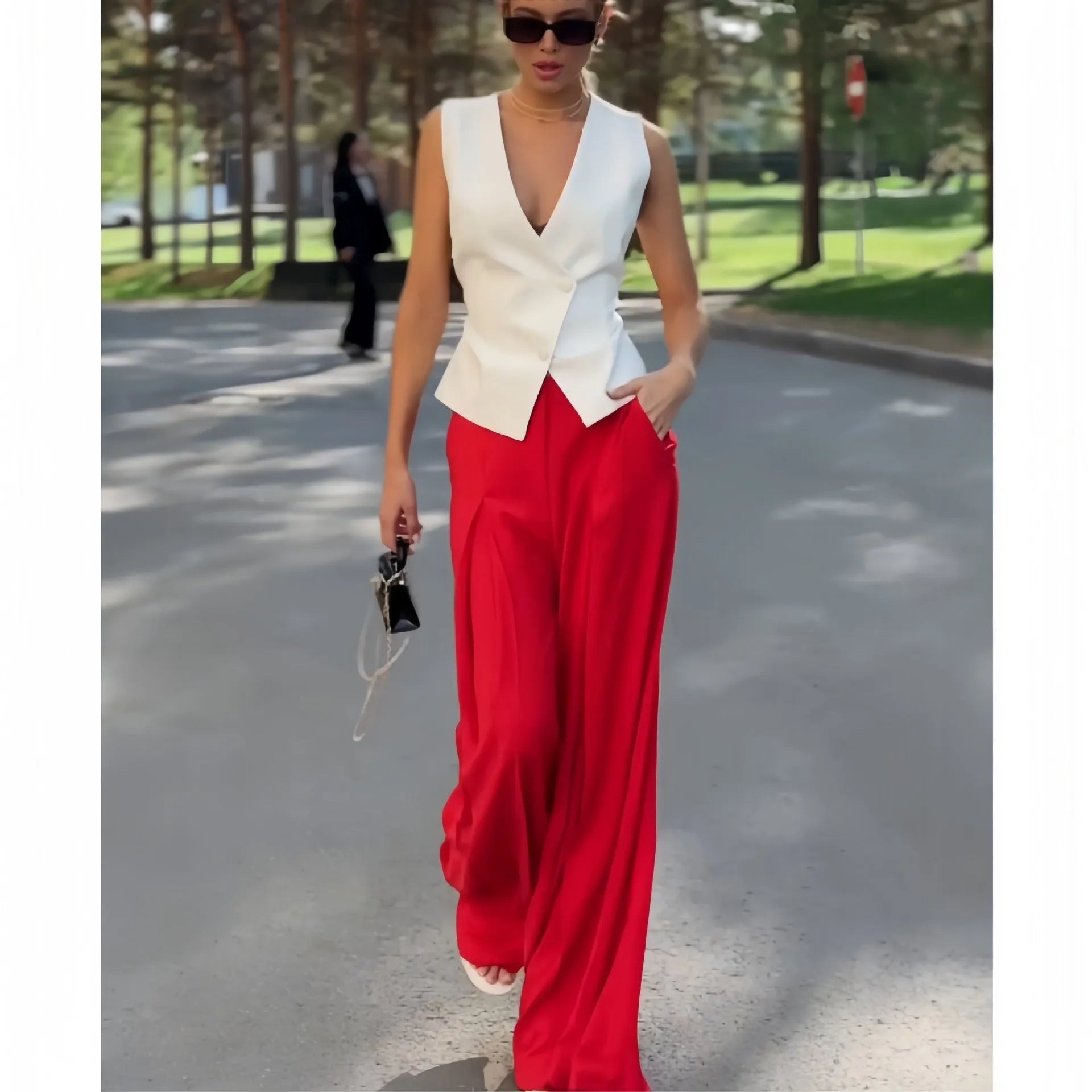Women's beige two-piece set with deep V-neck sleeveless top and high-waisted wide-leg trousers.