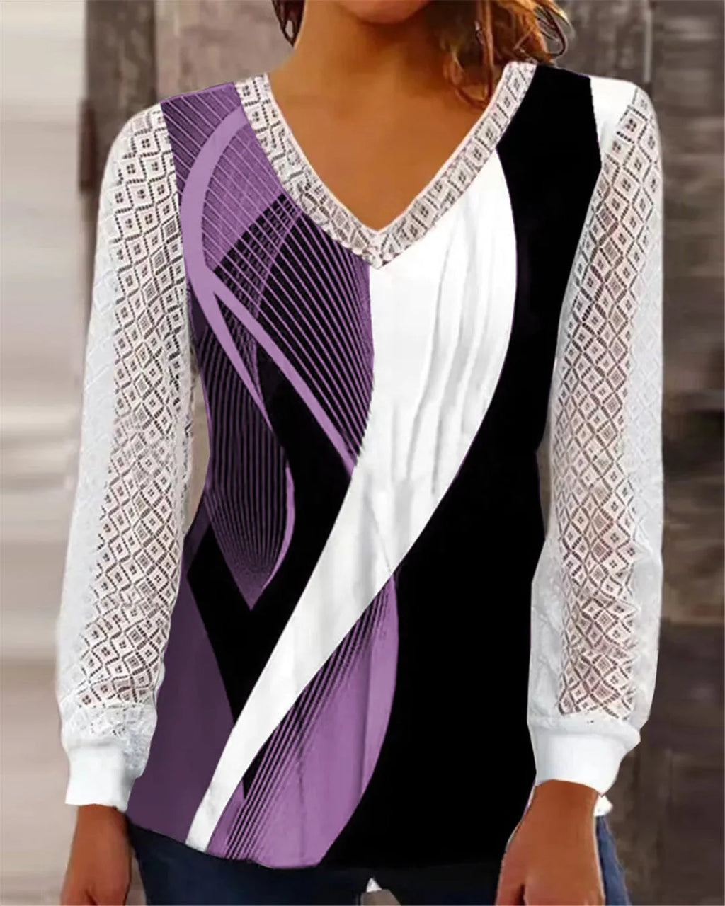 Purple loose V-neck top with lace print detail, long sleeves, on a hanger.