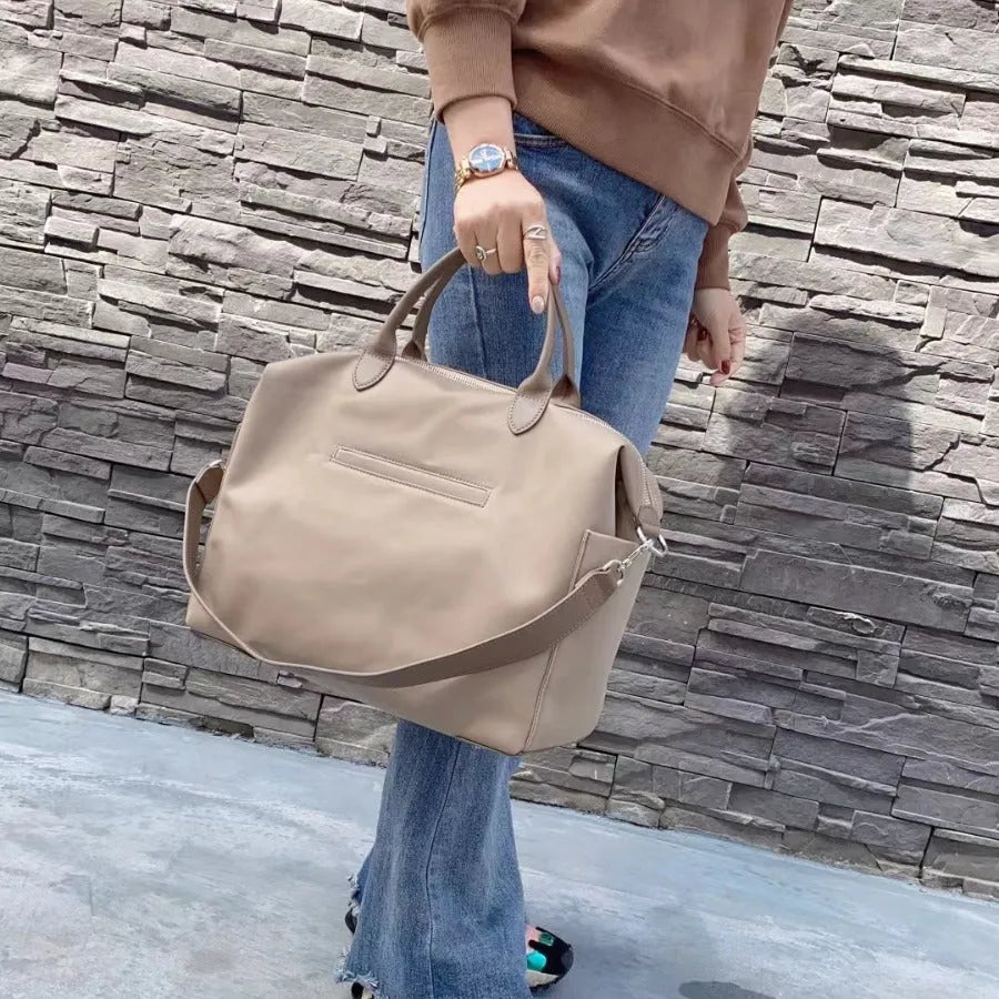 Waterproof nylon shoulder bag with leather accents in black colour showing large capacity interior