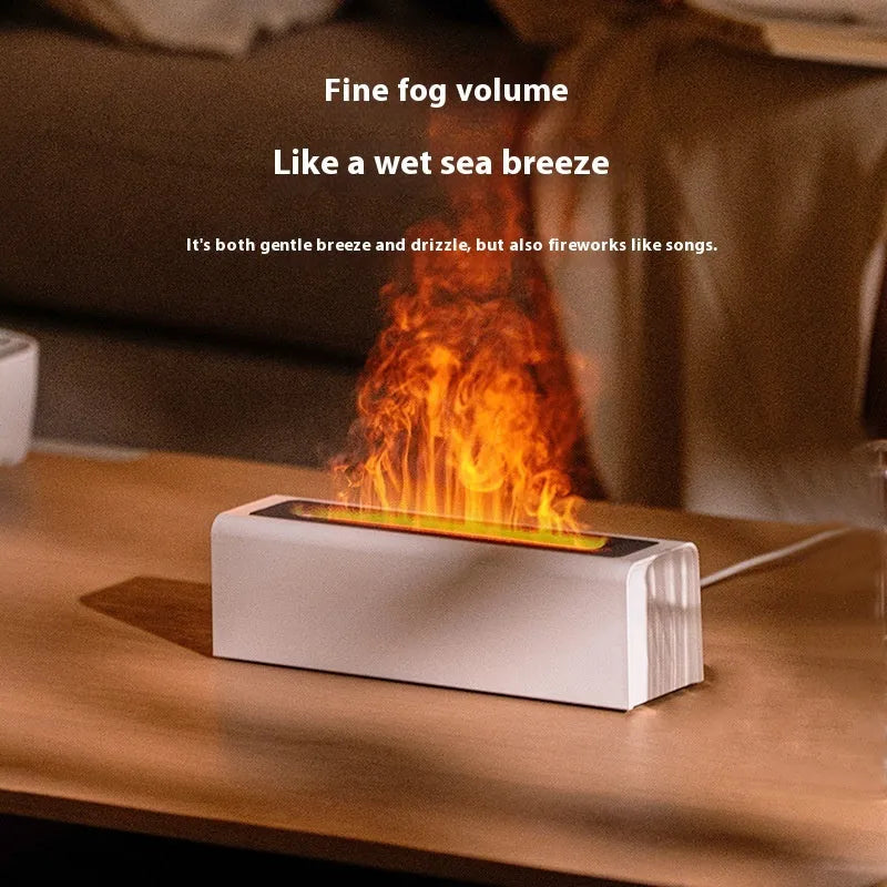 Black square USB aroma diffuser with colourful flame light effect and mist output on a wooden table.