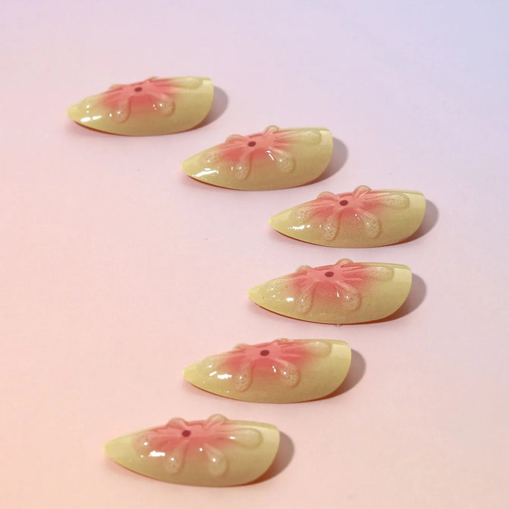 Set of plastic press-on nails with raised 3D cartoon flower design, jelly glue tube, and nail file.