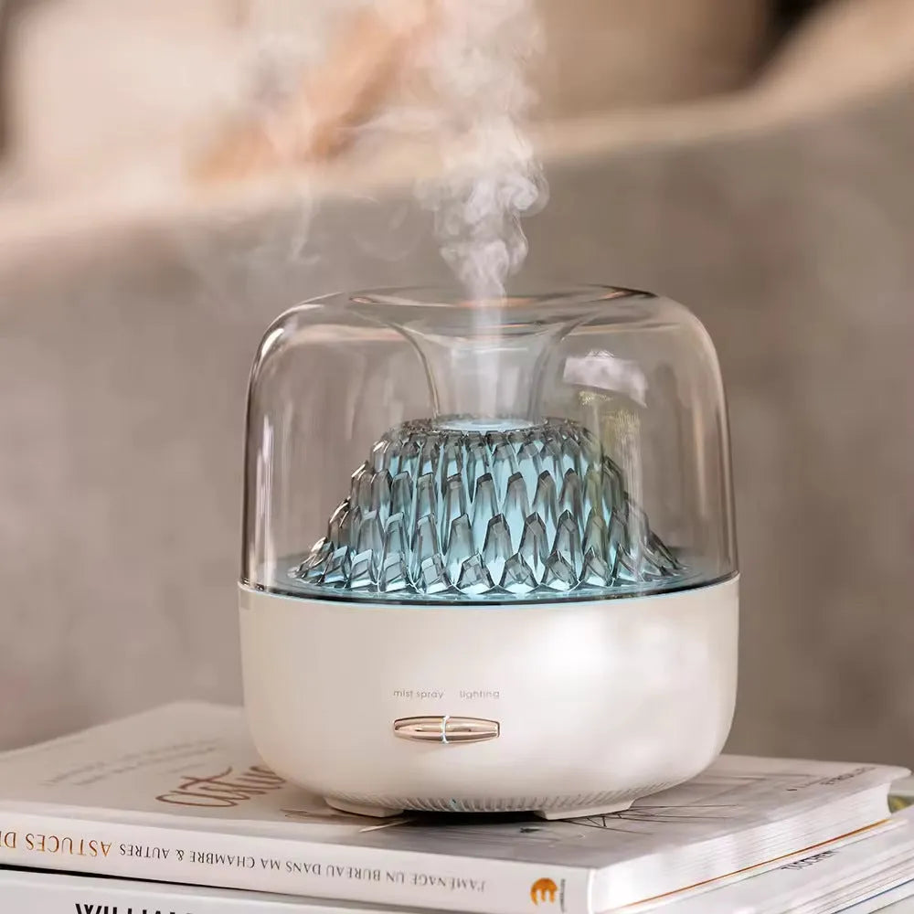 Round resin aroma diffuser in beige on a desk, with mist rising from single outlet, plug-in cord visible