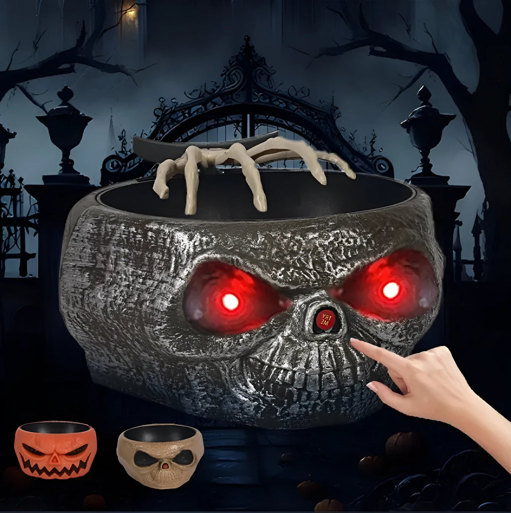 Plastic Halloween candy bowl with motion-activated skeleton hand and glowing red eyes on a table