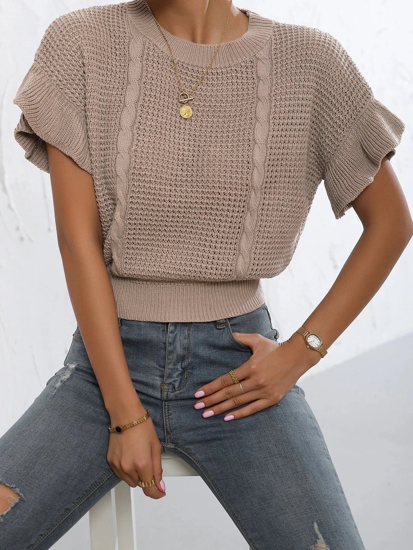 Knitted pullover sweater with ruffled short sleeves and a textured 3D pattern in a loose fit.