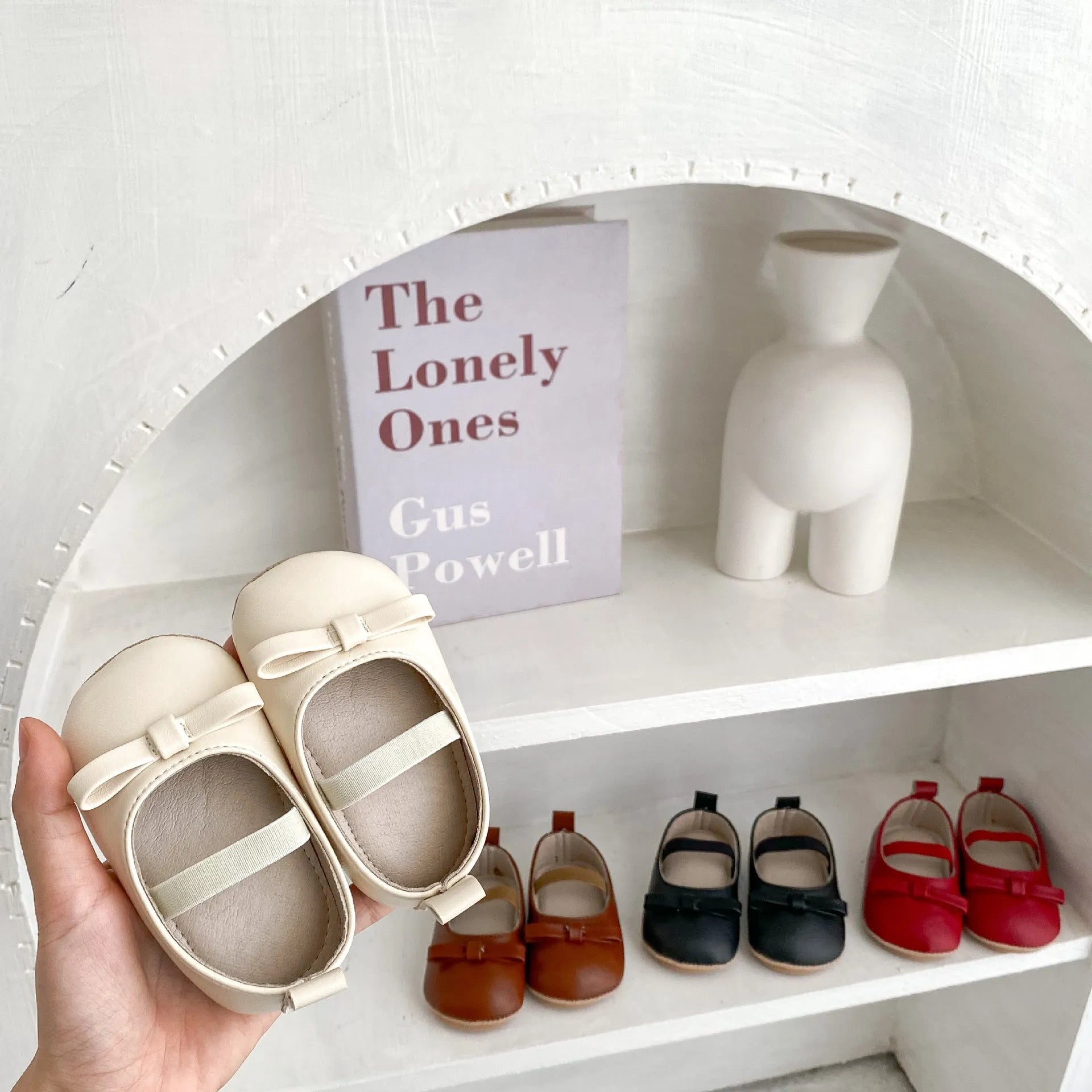 Baby shoes in white with bow detail, non-slip rubber sole, and elastic band fastening