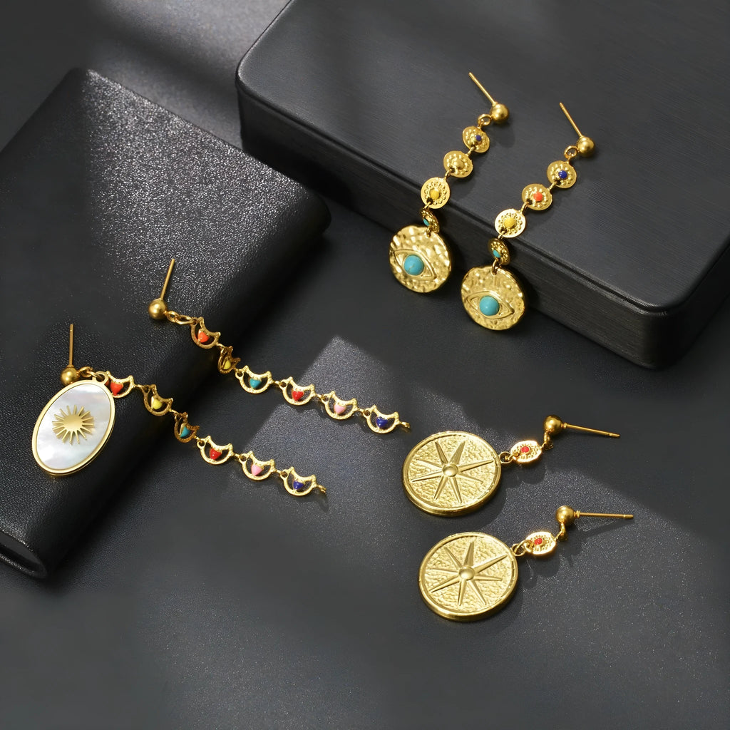Three pairs of geometric stainless steel earrings showing star, eye and shell sun designs