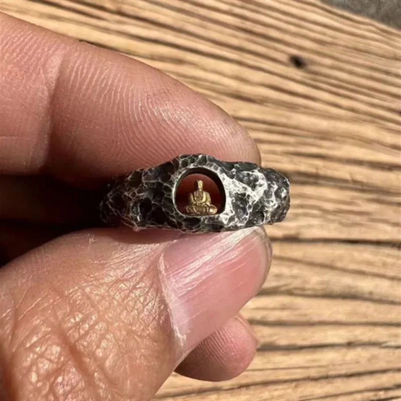Close-up of a hand-forged copper Grotto Buddha Ring with rock texture, showing the Buddha motif on a size 8 band.