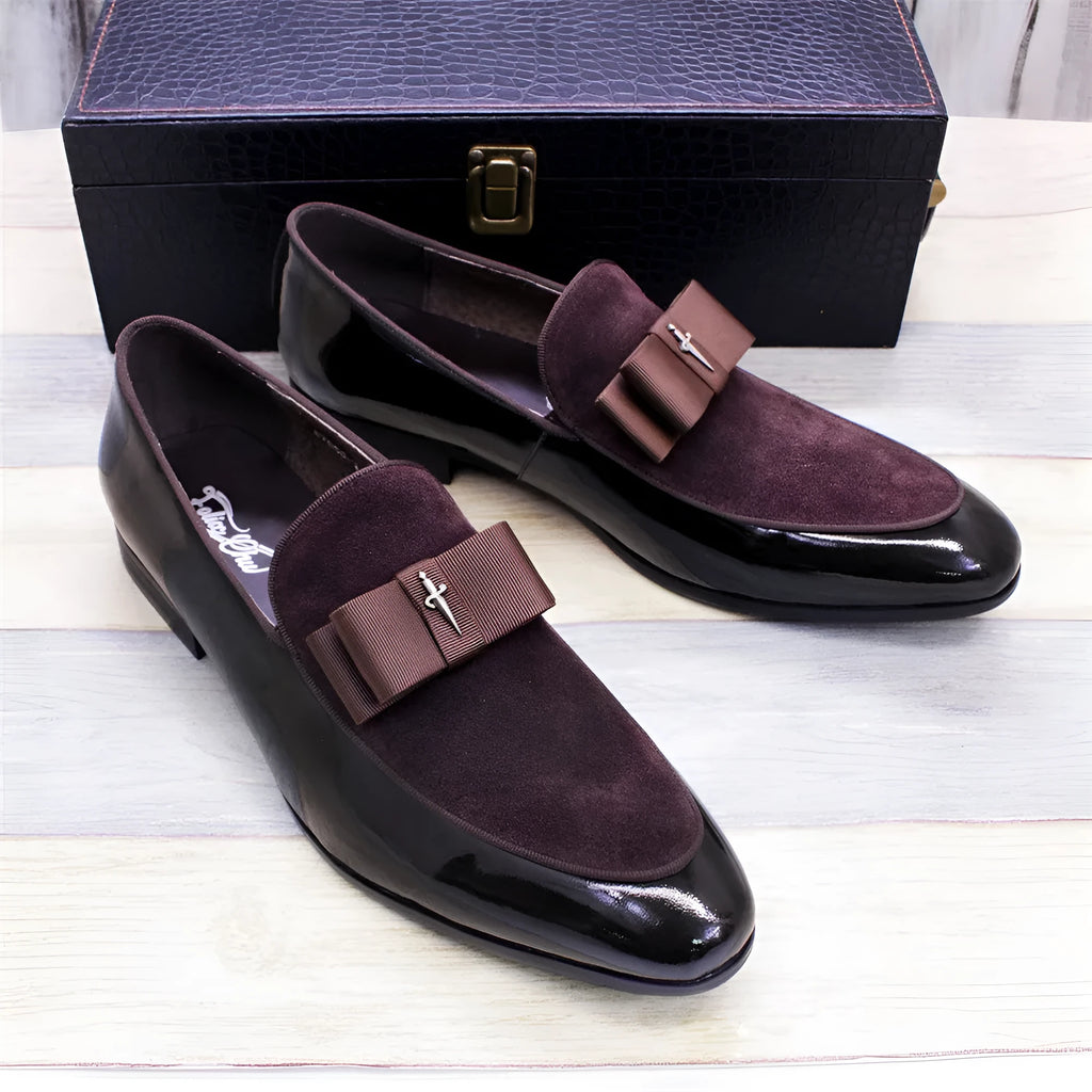 Men's black patent leather low-top shoes with a gold tassel detail on a white background.