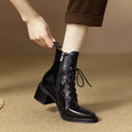 Women's black pointed-toe ankle boots with a short tube and block heel on a plain background