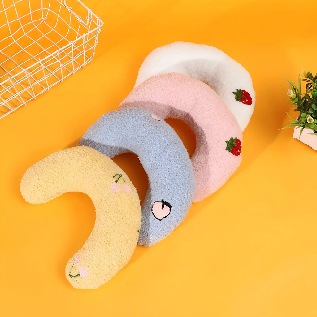 Blue U-shaped half moon cartoon pet pillow for a cat or small dog on a floor.