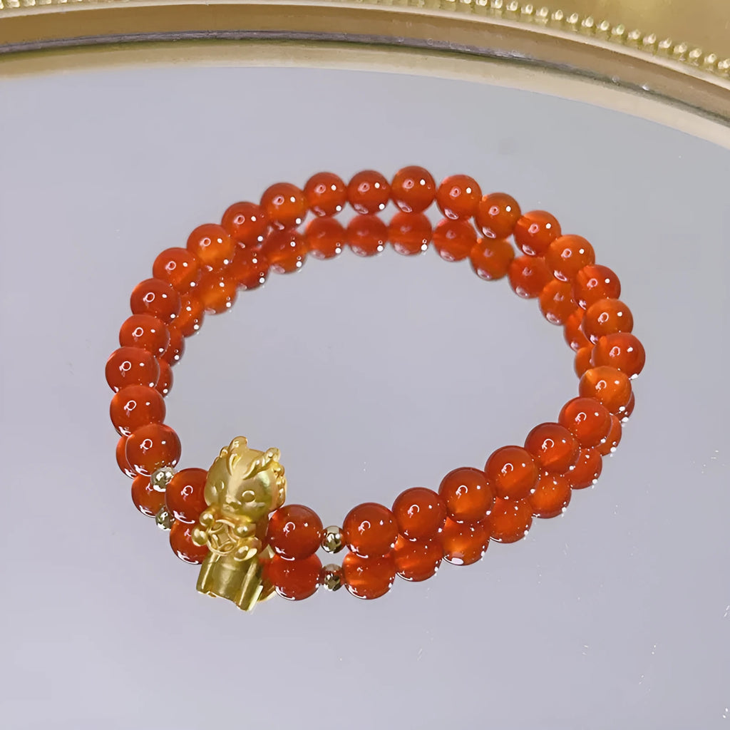 Handmade red agate women's bracelet with dragon design on a wrist.