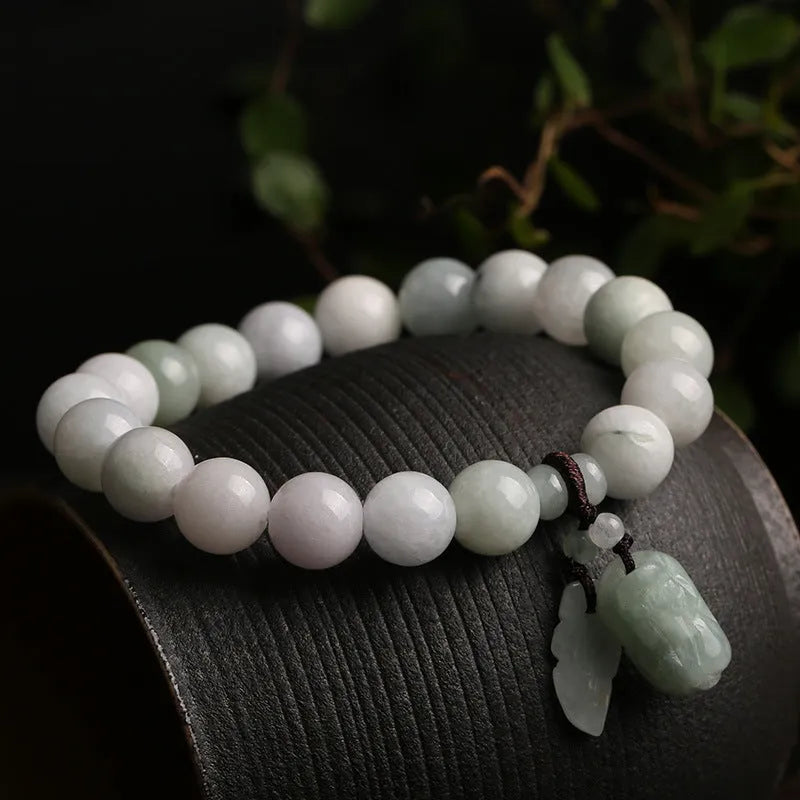 Apple green jade bracelet with carved Maitreya Buddha, gourd, and money bag beads.