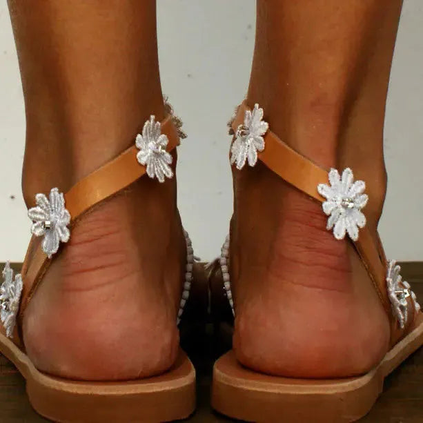 Brown women's Roman sandals with floral decoration on upper and flat rubber soles