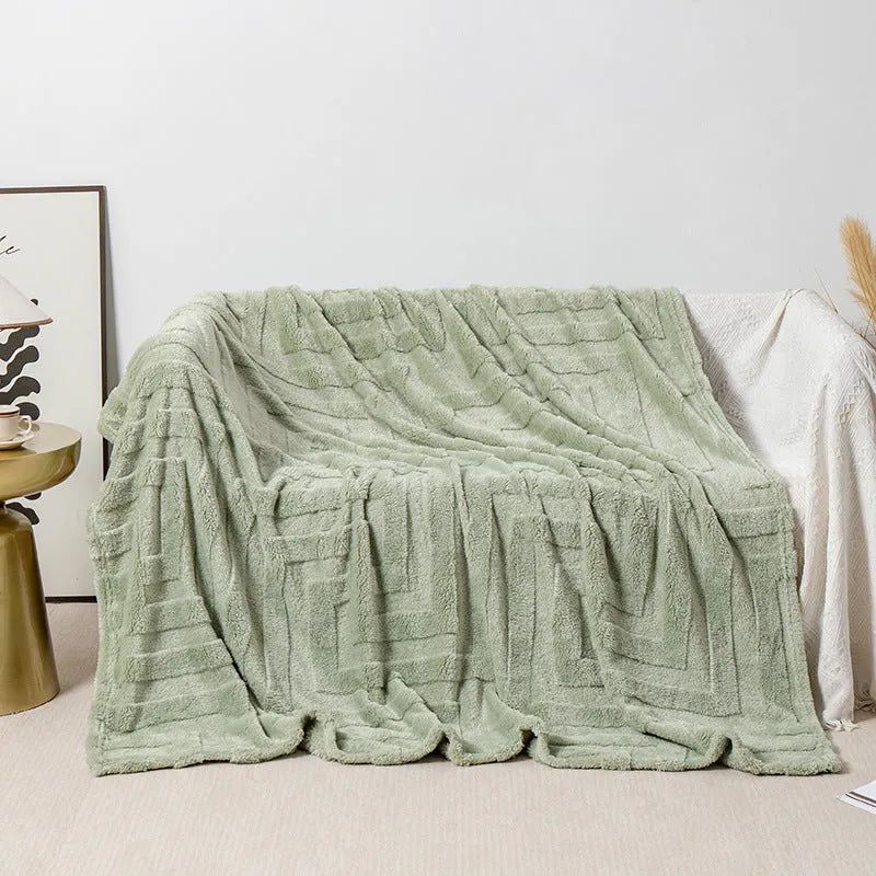 Thick square coral fleece flannel blanket in brown colour shown folded on a sofa