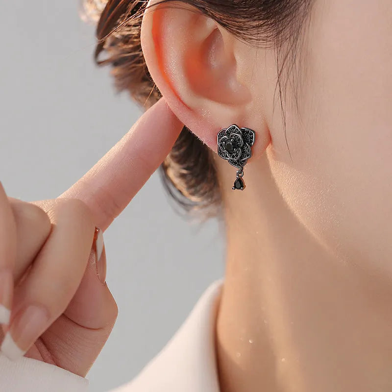 A pair of black rose zircon floral stud earrings with an 18K gold electroplated finish on copper.