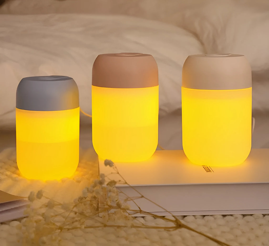 White cylindrical mini USB humidifier with aromatherapy function on a wooden surface.