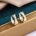 Pair of geometric drop earrings in 14K yellow with zircon treatment on a copper base.