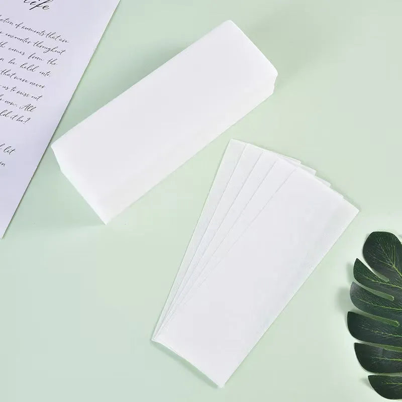 A pack of white non-woven fabric hair removal wax strips for body waxing.