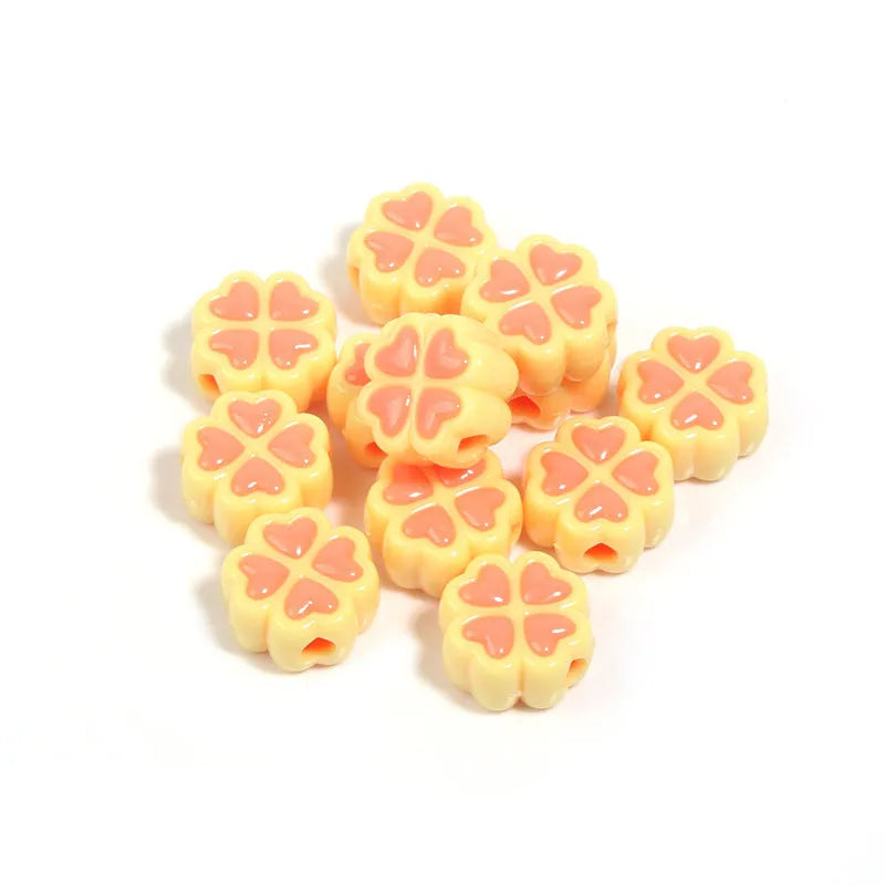 A selection of 15mm frosted acrylic beads in various colours, each showing a four-leaf clover love pattern.
