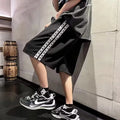 Men's black baggy track pants with loose fit and elastic waistband