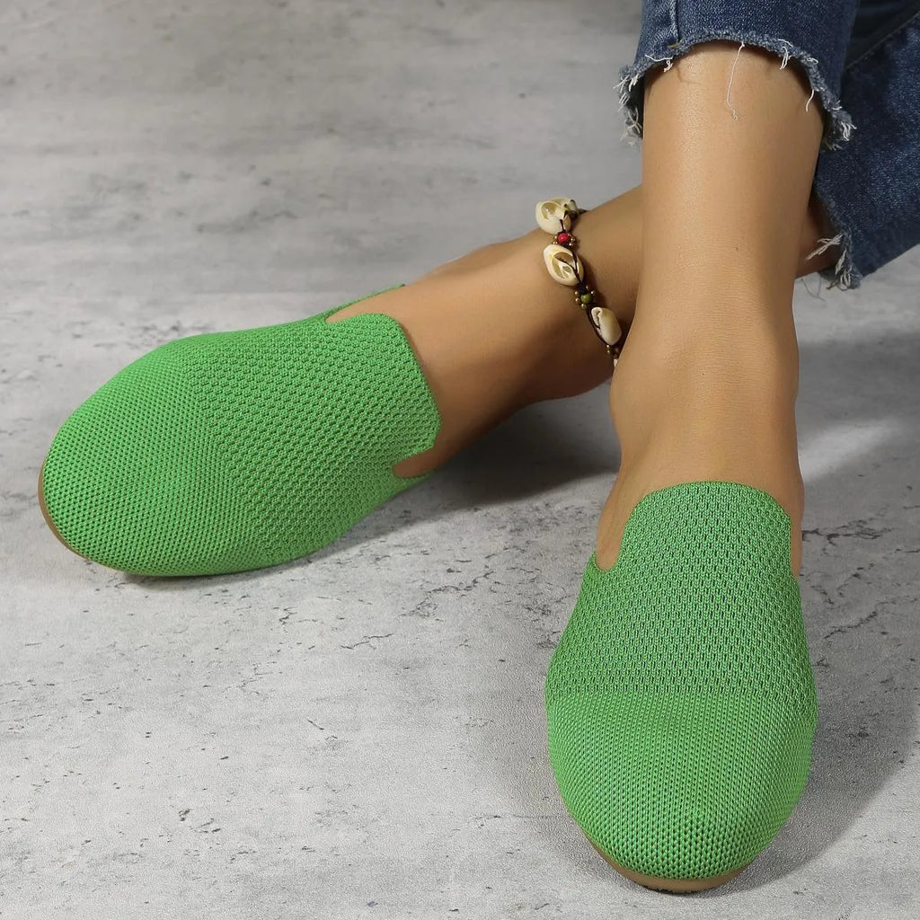 A pair of apricot-coloured mesh slip-on flat sandals with a round toe and rubber sole.