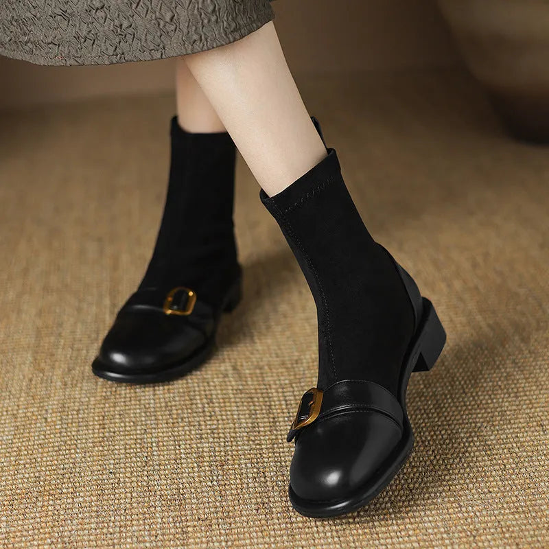 Women's black low heel Martin boots with lace-up front and belt buckle stitching detail on a round toe.