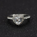 Heart-shaped crystal wedding ring in rose gold or silvery finish on white background