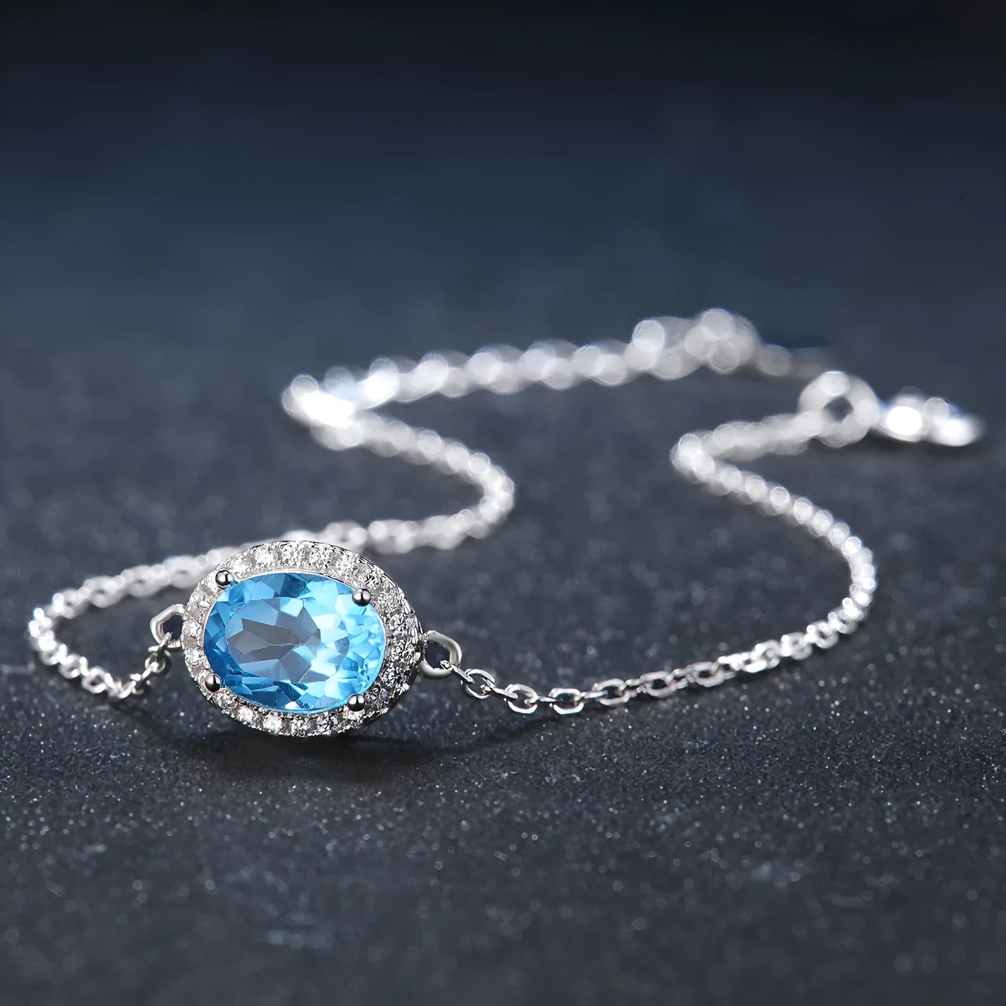 Four-piece sterling silver jewellery set with blue topaz stones including geometric earrings, ring, bracelet and necklace