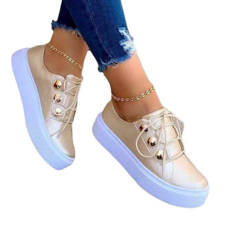 Women's white lace-up flats sneakers with silver rivet detail on the casual round-toe upper.