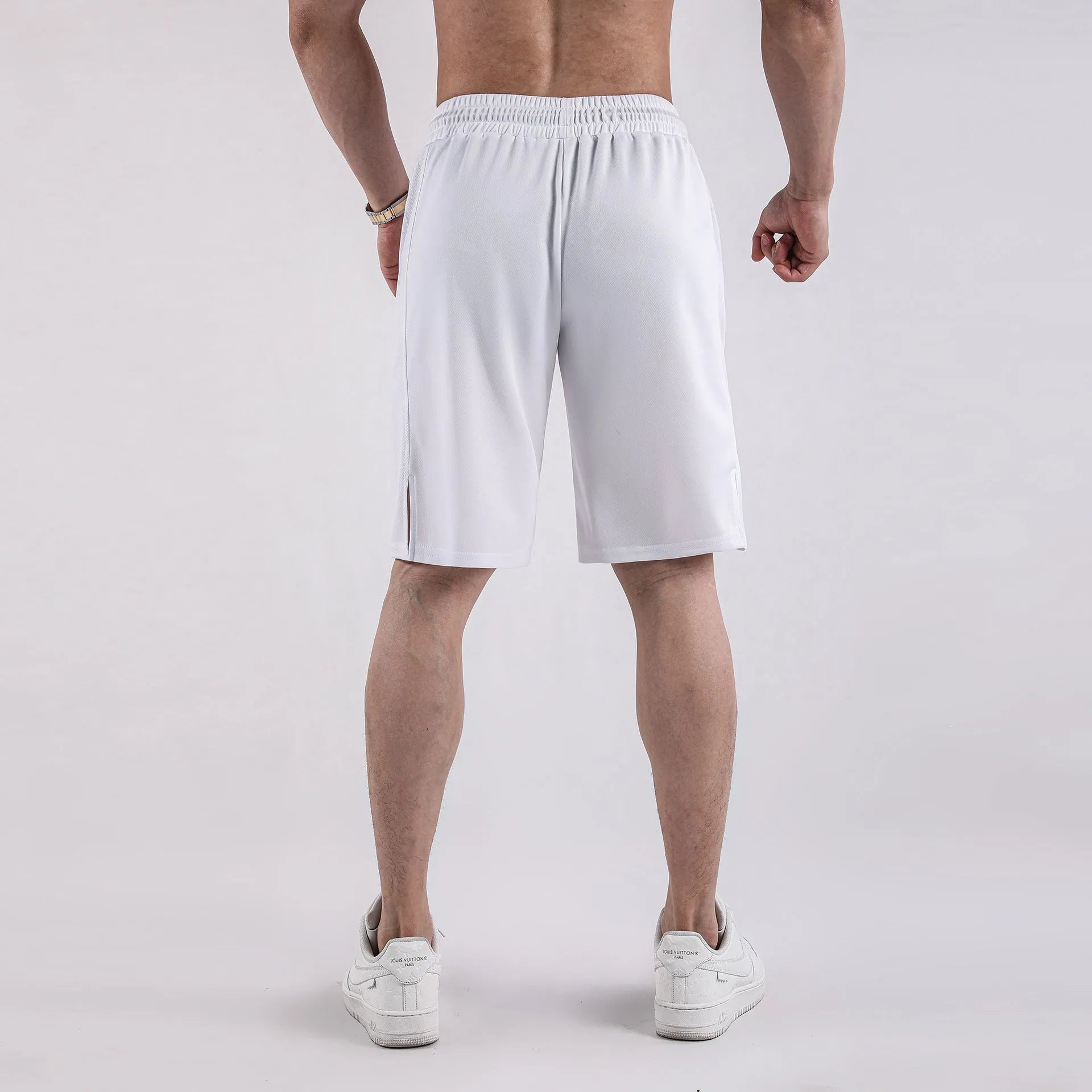 Man wearing black loose-fit quick-dry mesh fitness shorts with an elastic waistband.