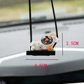 Colourful resin astronaut cartoon character car pendant hanging from a sun visor.