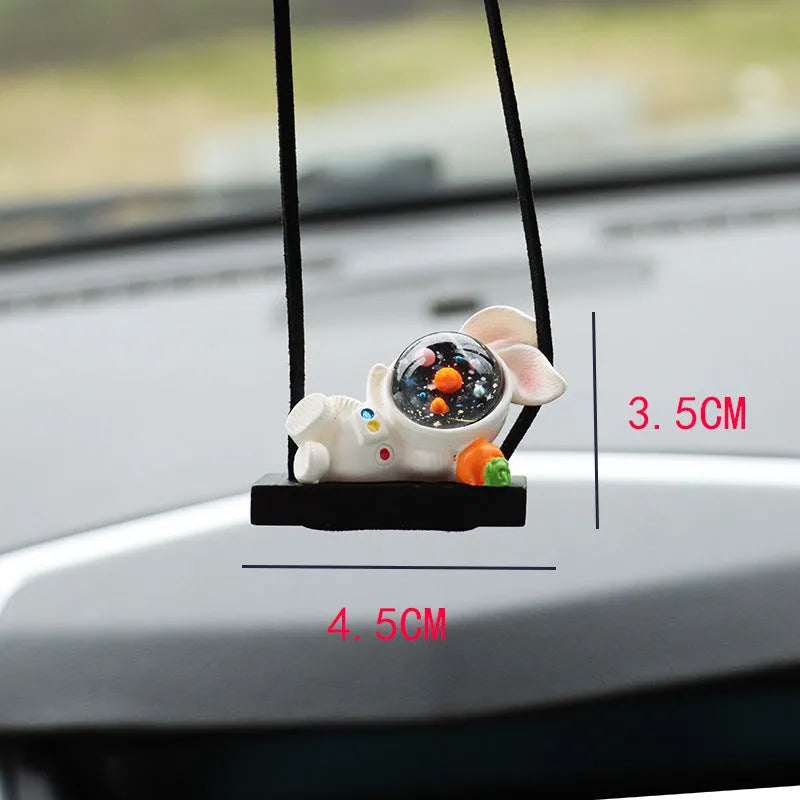 Colourful resin astronaut cartoon character car pendant hanging from a sun visor.