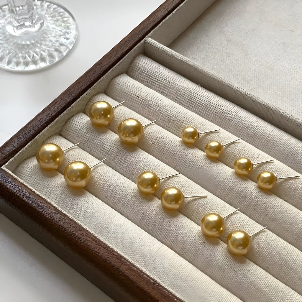 A pair of large pearl stud earrings with an eight-point star geometric setting in silver.