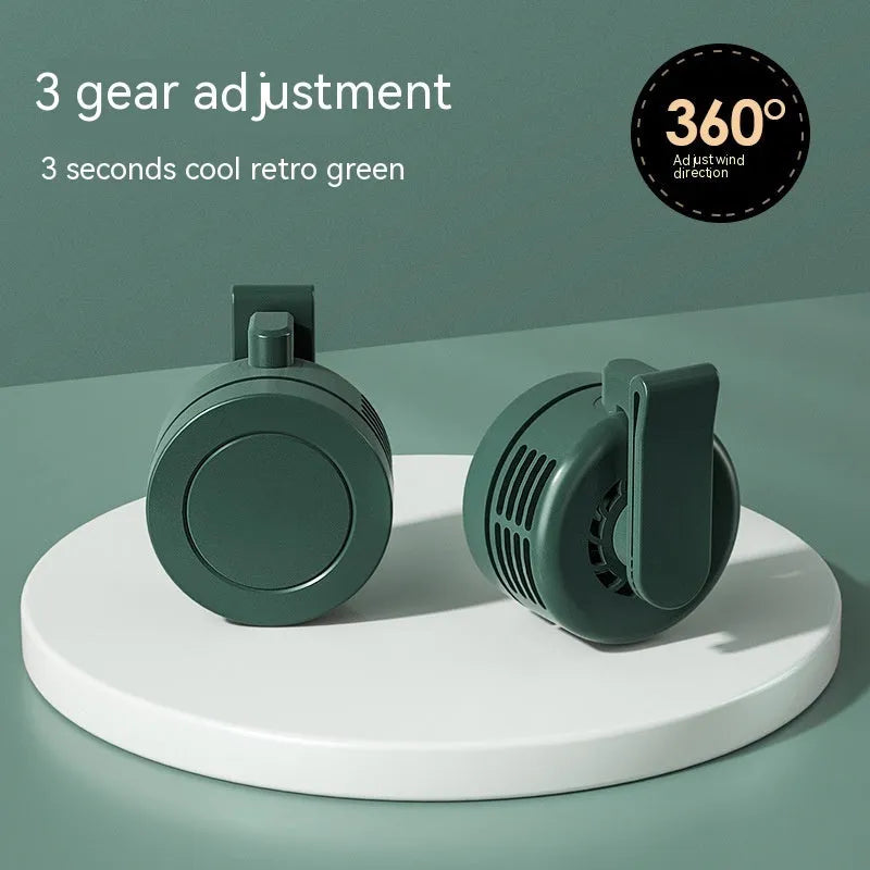 Green wrist-mounted fan with blades, LED light, and USB charging port on a silicone strap.