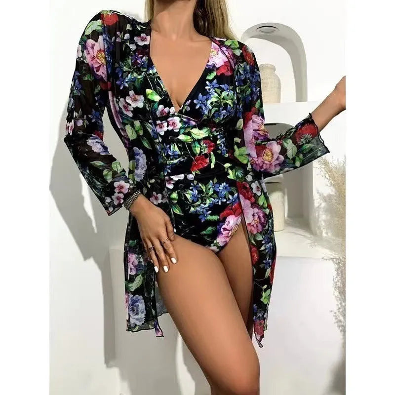 Women's floral print three-piece bikini set with a cover-up coat on a hanger
