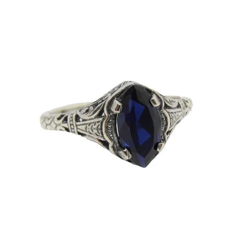 Silver geometric hollow women's ring on grey background showing detailed pattern