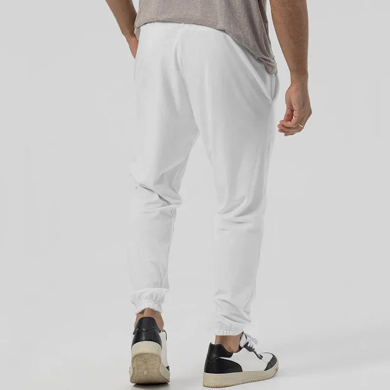 Men's grey straight-leg casual track sweatpants made from cotton blend fabric on a neutral background.
