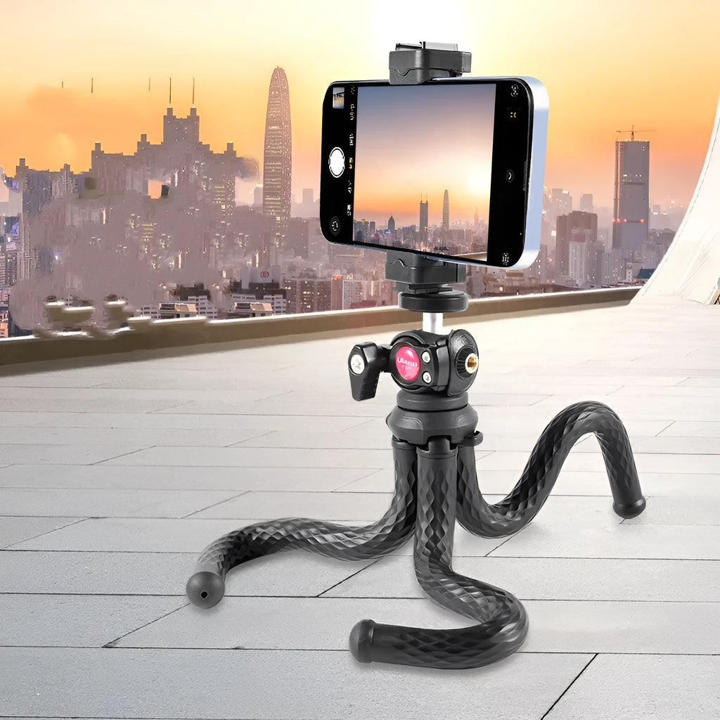 Black octopus-style flexible tripod with mobile phone clip extended on a table.