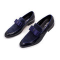 Men's black patent leather low-top shoes with a gold tassel detail on a white background.