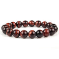 Natural tiger's eye crystal bead bracelet with round beads on a wrist, showing colour variations.