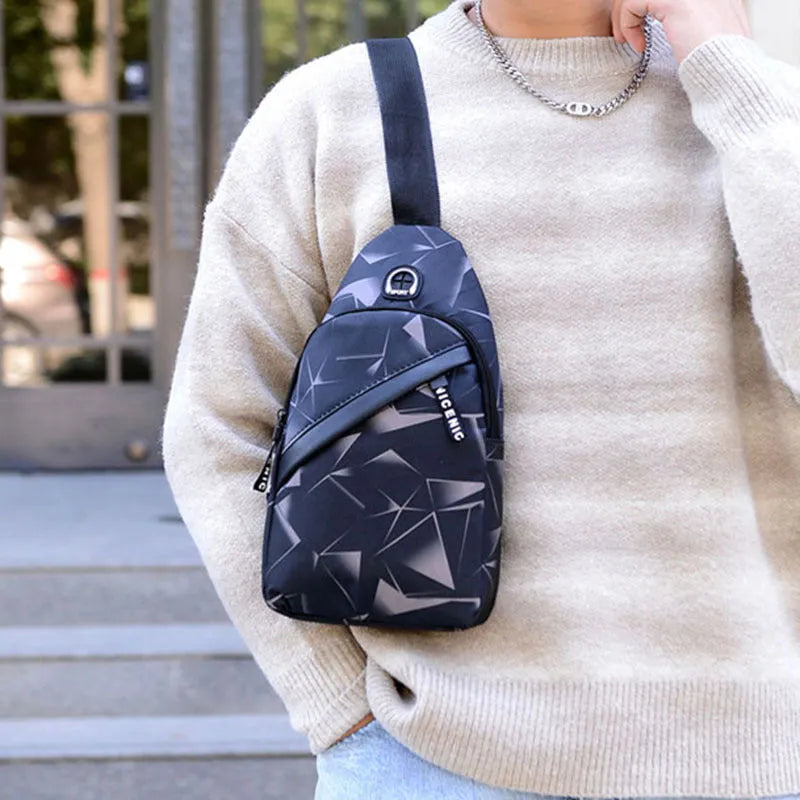 Men's blue print sling chest bag with earphone hole, shown worn crossbody.