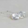 Silver-tone women's earrings with bird and leaf motifs in glossy round retro design