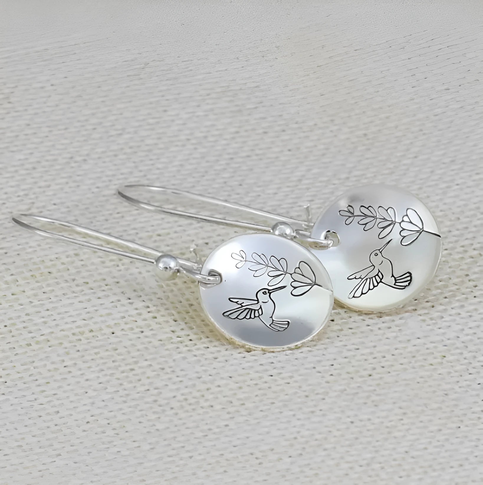 Silver-tone women's earrings with bird and leaf motifs in glossy round retro design